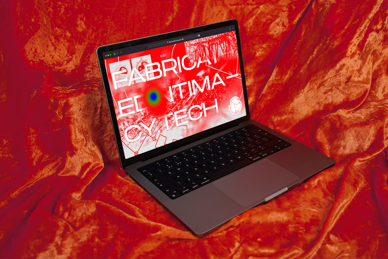 alt: A laptop ontop of a nicely lit bright orange fabric, on the laptop screen is the Fabricated Intimacy website