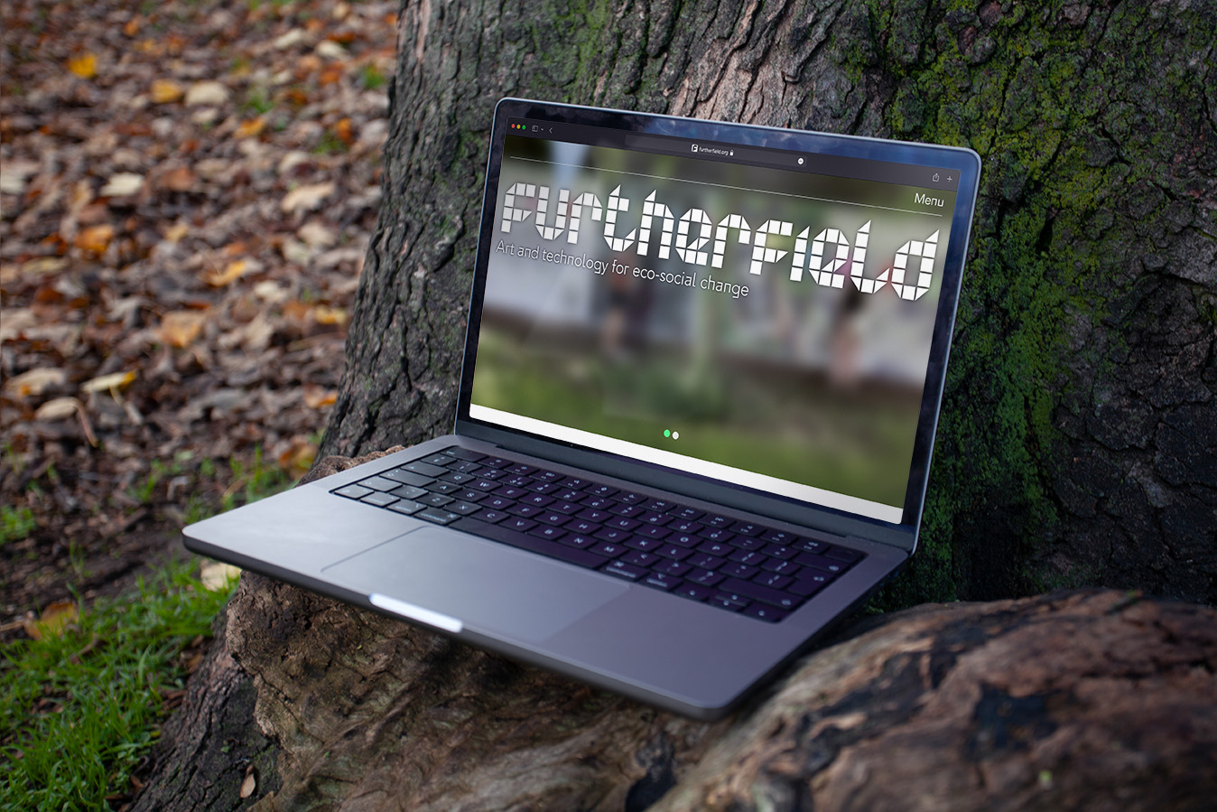 alt: A laptop resting by a tree, displayed on it's screen is the furtherfield website