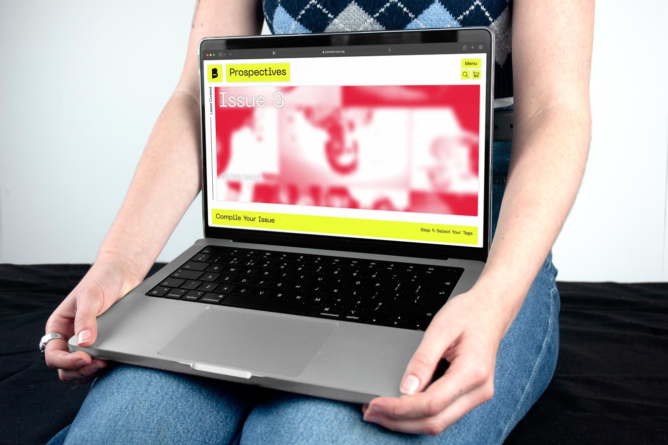 A laptop resting on a persons lap, showing the Prospectives website on the laptop screen