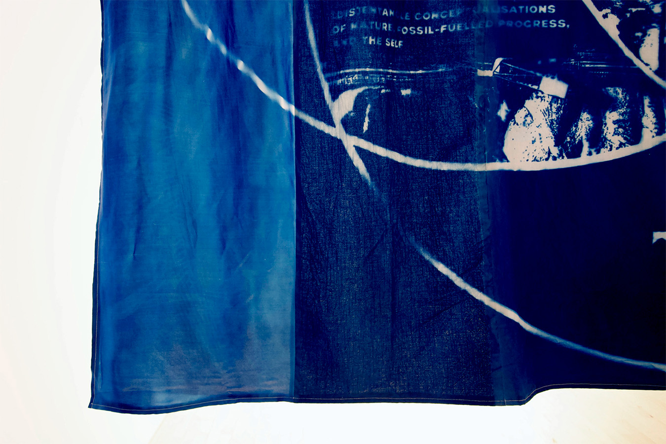 a close up of a large blue dyed material comprising of different fabrics sewn together with a showing details of the cyanotype