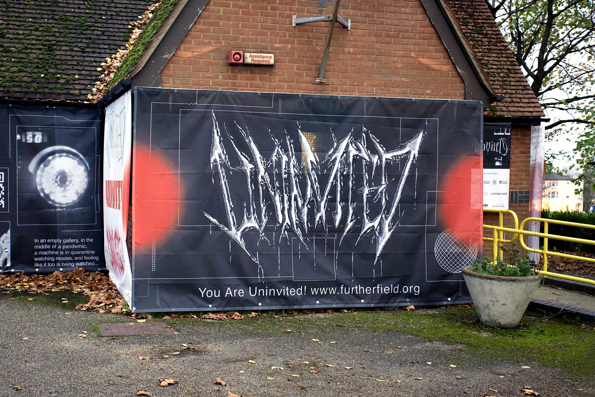 alt: A large banner on the side of Futher Field Gallery with the word Univited written on it in spikey metal type.